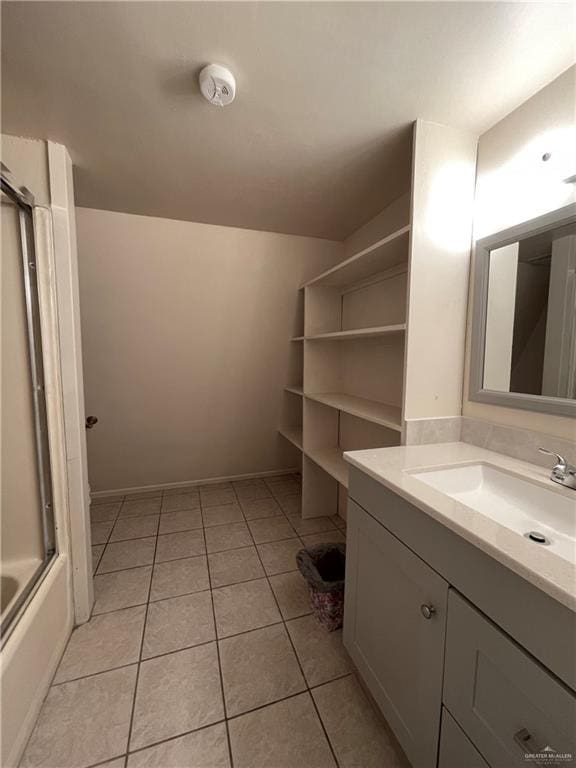 bathroom with tile patterned flooring, vanity, and shower / bath combination with glass door