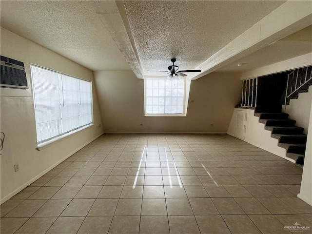 empty room featuring tile patterned floors, ceiling fan, a wall mounted air conditioner, and a textured ceiling