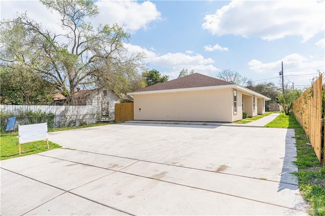 view of side of home with fence and stucco siding