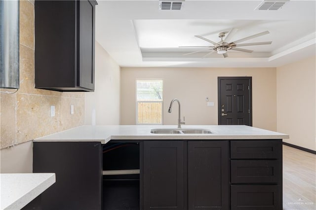 kitchen featuring visible vents, a tray ceiling, and a sink