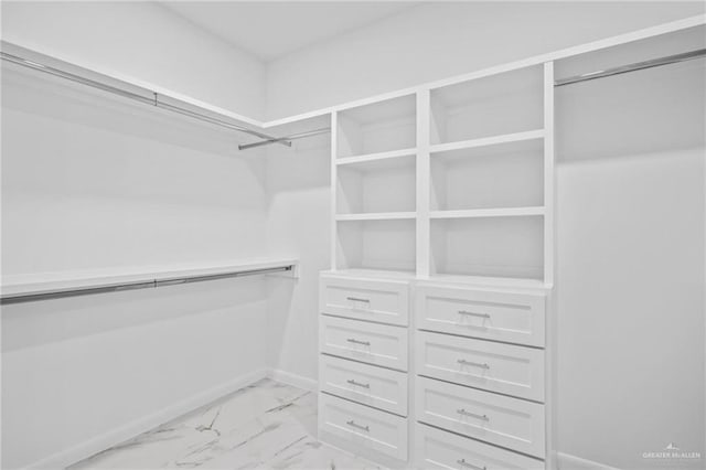 walk in closet featuring marble finish floor