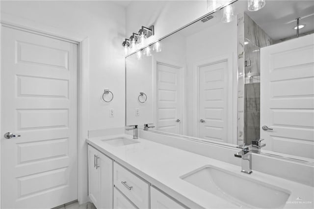 bathroom with visible vents, a sink, a shower stall, and double vanity