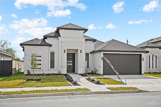 view of front of home with a shingled roof, a front yard, fence, a garage, and driveway