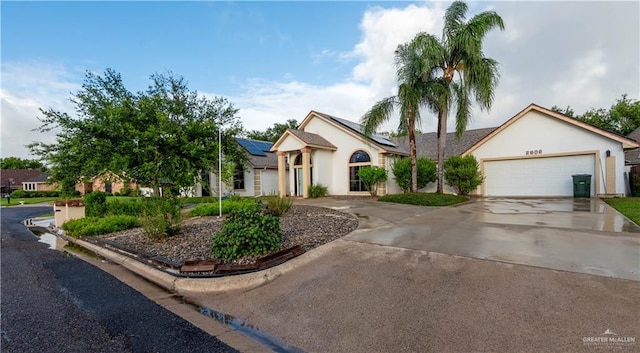 single story home featuring a garage and solar panels