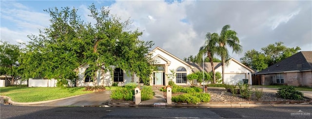 view of property hidden behind natural elements featuring a front lawn