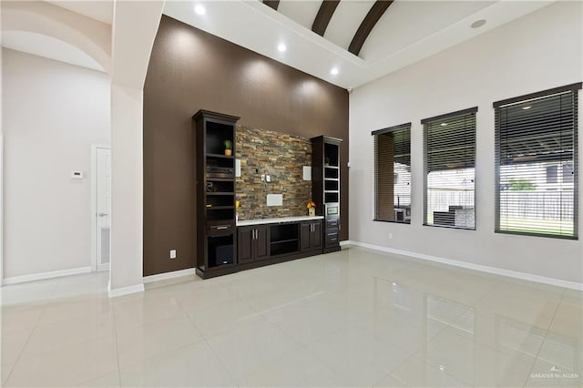 5013 Nevis Dr, Edinburg, TX 78539 - unfurnished living room with light tile patterned floors, baseboards, high vaulted ceiling, and recessed lighting