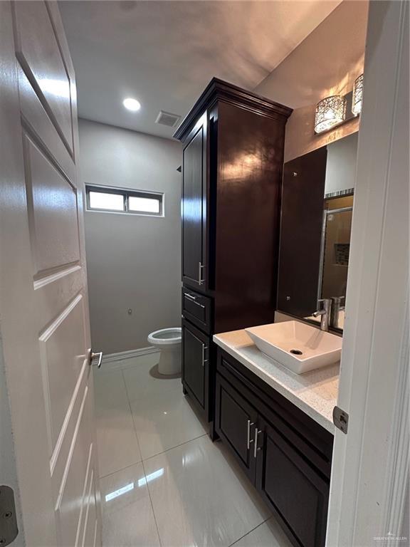 5013 Nevis Dr, Edinburg, TX 78539 - bathroom with vanity, toilet, tile patterned floors, and baseboards