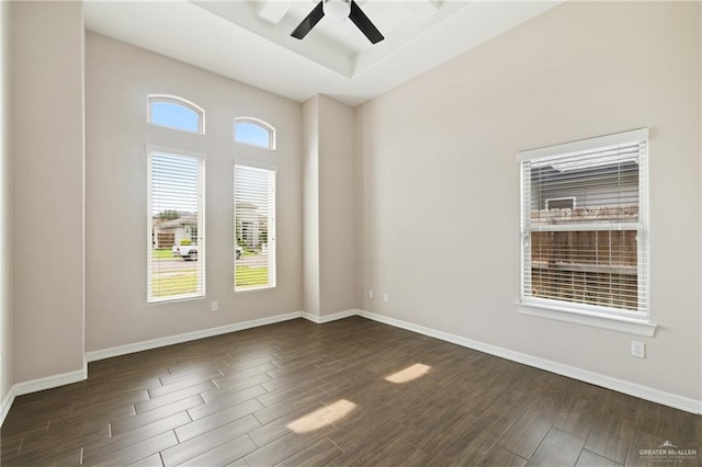 5013 Nevis Dr, Edinburg, TX 78539 - spare room with dark wood-type flooring, ceiling fan, baseboards, and a tray ceiling