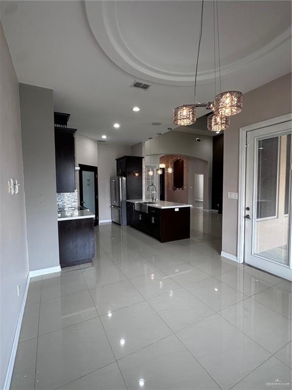 5013 Nevis Dr, Edinburg, TX 78539 - kitchen with freestanding refrigerator, baseboards, arched walkways, light countertops, and recessed lighting