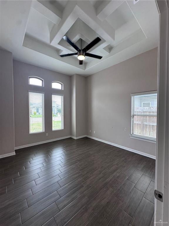 5013 Nevis Dr, Edinburg, TX 78539 - empty room featuring coffered ceiling, dark wood-type flooring, a ceiling fan, baseboards, and beam ceiling