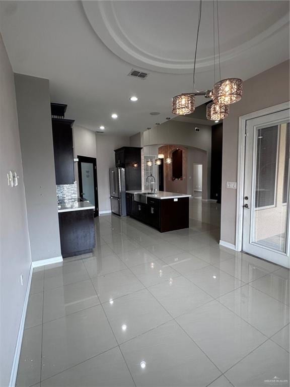 5013 Nevis Dr, Edinburg, TX 78539 - kitchen with baseboards, arched walkways, light countertops, freestanding refrigerator, and recessed lighting