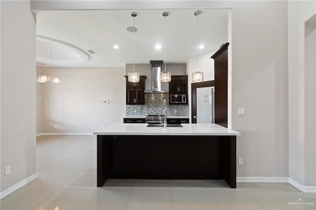 5013 Nevis Dr, Edinburg, TX 78539 - kitchen featuring stainless steel microwave, wall chimney range hood, a sink, light countertops, and decorative backsplash