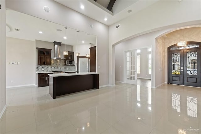 5013 Nevis Dr, Edinburg, TX 78539 - kitchen with stainless steel microwave, wall chimney range hood, french doors, light tile patterned floors, and recessed lighting