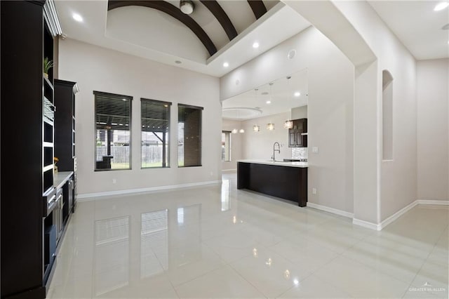 5013 Nevis Dr, Edinburg, TX 78539 - unfurnished living room with recessed lighting, light tile patterned floors, baseboards, a sink, and high vaulted ceiling