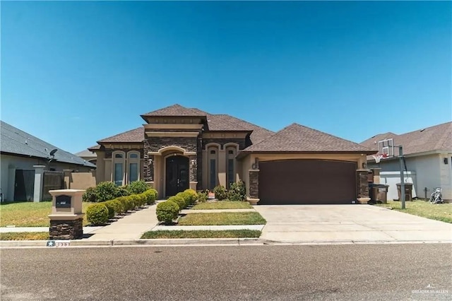 5013 Nevis Dr, Edinburg, TX 78539 - mediterranean / spanish house featuring stone siding, a garage, concrete driveway, and stucco siding
