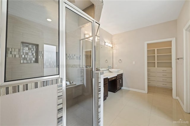 5013 Nevis Dr, Edinburg, TX 78539 - bathroom featuring a shower stall, vanity, a walk in closet, baseboards, and tile patterned floors