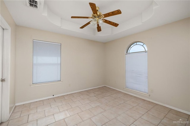 unfurnished room featuring a raised ceiling and ceiling fan