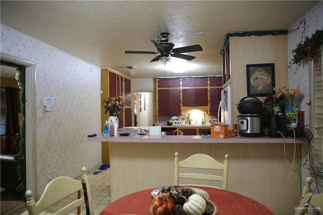 kitchen featuring kitchen peninsula, ceiling fan, a textured ceiling, and white refrigerator