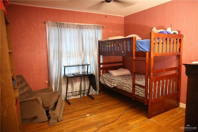 bedroom featuring hardwood / wood-style floors, ceiling fan, and ornamental molding