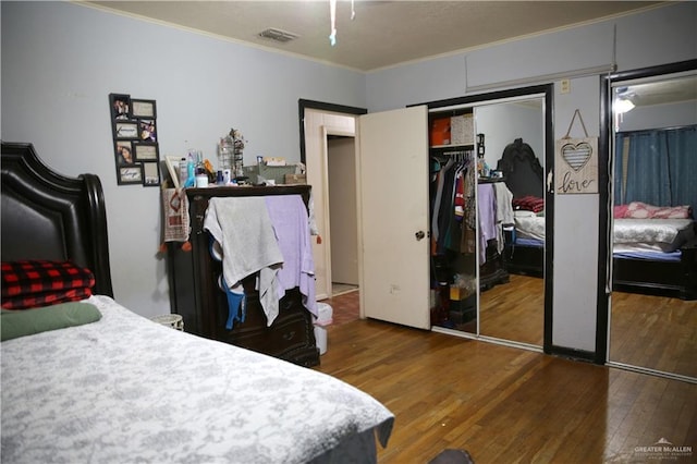 bedroom featuring crown molding, a closet, and wood-type flooring