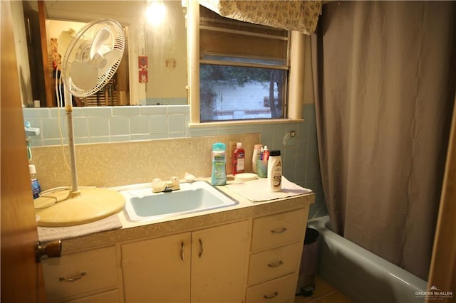 bathroom with decorative backsplash, vanity, and shower / bathtub combination with curtain