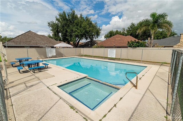 view of pool featuring an in ground hot tub and a patio