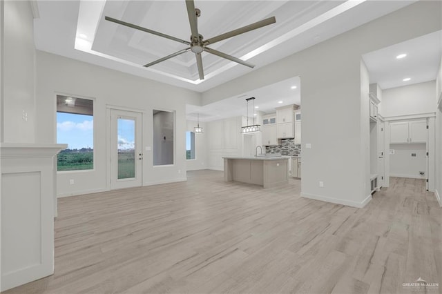1007 Broken Arrow Dr, Alamo, TX 78516 - unfurnished living room with ceiling fan, light wood-style floors, and a sink