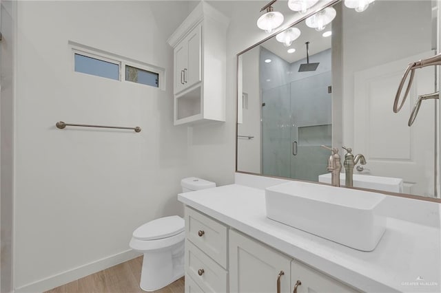 1007 Broken Arrow Dr, Alamo, TX 78516 - bathroom featuring vanity, toilet, a stall shower, baseboards, and wood finished floors