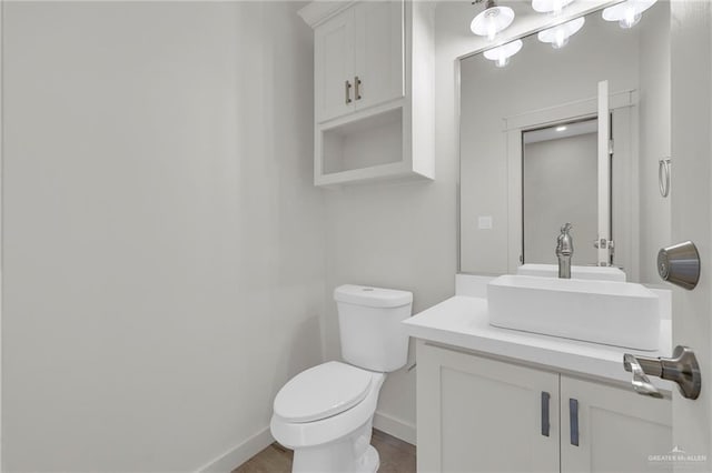 1007 Broken Arrow Dr, Alamo, TX 78516 - half bath featuring toilet, wood finished floors, vanity, and baseboards