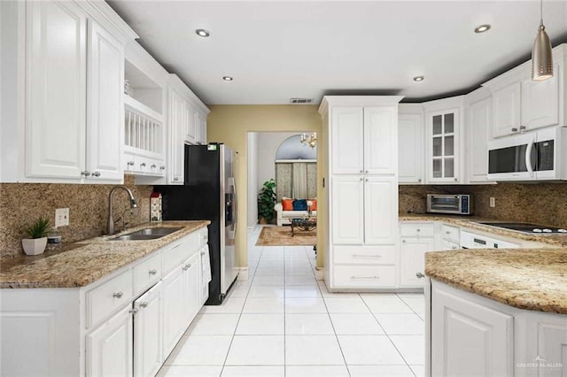 kitchen featuring white cabinets, sink, black electric cooktop, light tile patterned floors, and light stone counters