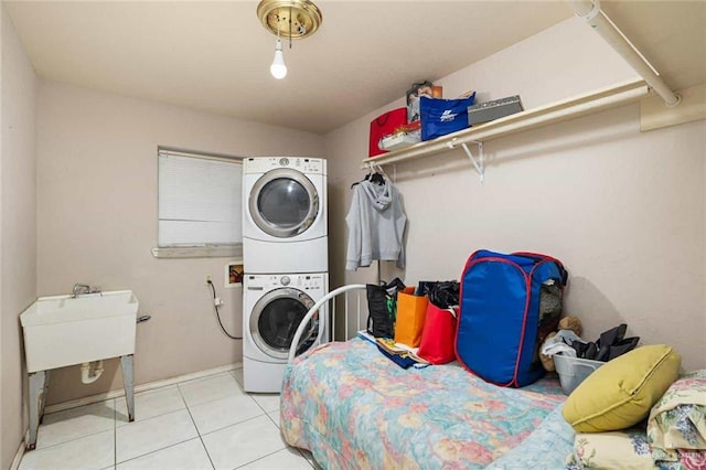 laundry area featuring light tile patterned floors and stacked washer and clothes dryer