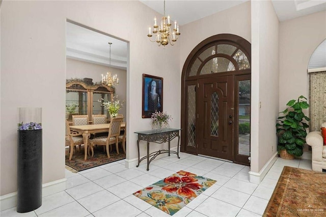 tiled foyer entrance featuring a high ceiling and a chandelier