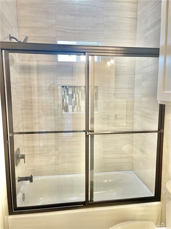 bathroom with shower / bath combination with glass door