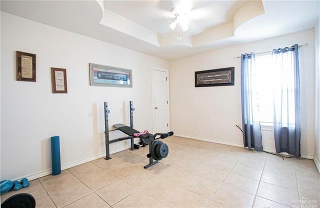 2209 Benito A Ramirez Rd, Edinburg, TX 78542 - exercise room featuring a tray ceiling, a ceiling fan, light tile patterned floors, and baseboards