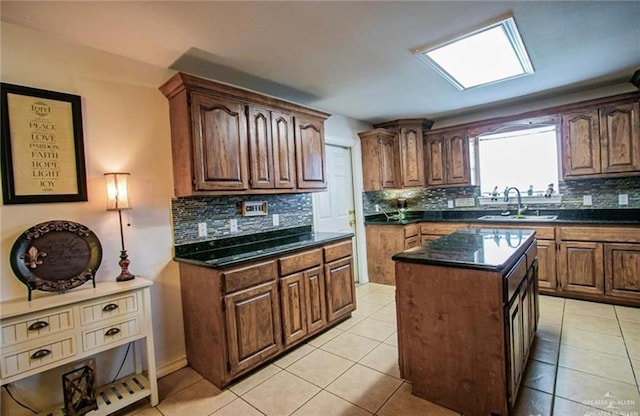 2209 Benito A Ramirez Rd, Edinburg, TX 78542 - kitchen featuring a sink, tasteful backsplash, a center island, light tile patterned flooring, and dark stone counters