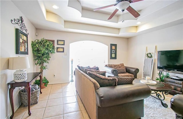 2209 Benito A Ramirez Rd, Edinburg, TX 78542 - living area with a ceiling fan, light tile patterned floors, a tray ceiling, arched walkways, and baseboards