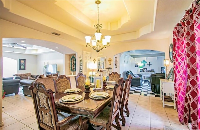 2209 Benito A Ramirez Rd, Edinburg, TX 78542 - dining room featuring a tray ceiling, arched walkways, and light tile patterned flooring
