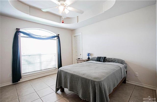 2209 Benito A Ramirez Rd, Edinburg, TX 78542 - bedroom with a tray ceiling, light tile patterned floors, baseboards, and a ceiling fan