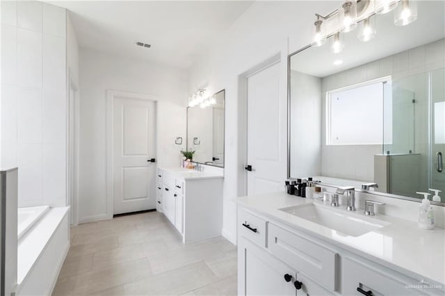 7423 Converse Lk, Brownsville, TX 78520 - bathroom featuring two vanities, a bath, a shower stall, tile patterned flooring, and baseboards
