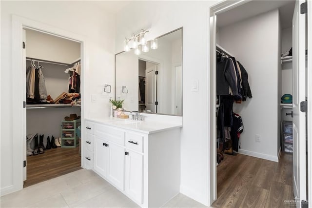7423 Converse Lk, Brownsville, TX 78520 - bathroom with a spacious closet, vanity, wood finished floors, and baseboards