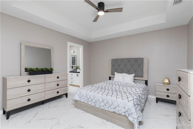 1712 B St, Mission, TX 78572 - bedroom featuring a tray ceiling, light marble finish floors, baseboards, ensuite bath, and a ceiling fan