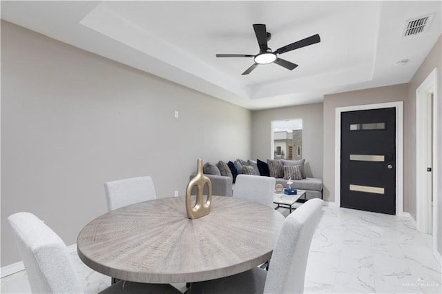 1712 B St, Mission, TX 78572 - dining area with a tray ceiling, a ceiling fan, light marble finish flooring, and baseboards