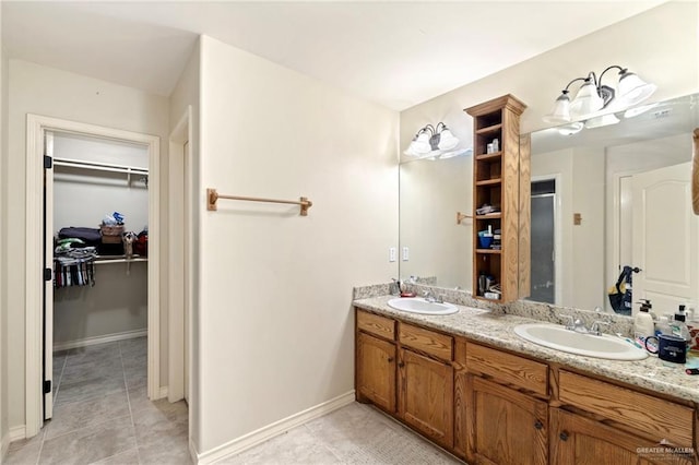 2017 Stonebriar Rd, Harlingen, TX 78552 - bathroom featuring double vanity, tile patterned flooring, and a walk in closet