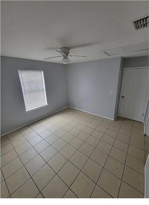 unfurnished room featuring visible vents, ceiling fan, and light tile patterned floors