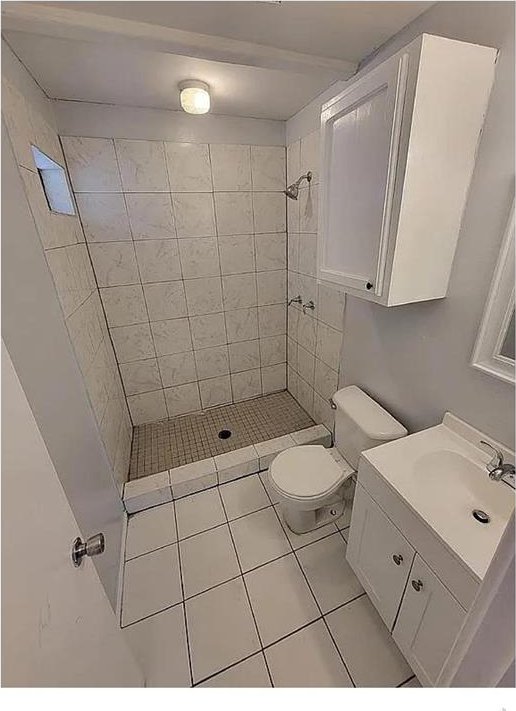 full bath with vanity, a shower stall, toilet, and tile patterned floors