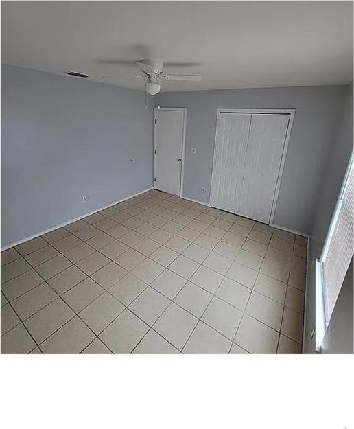 unfurnished bedroom with a ceiling fan, a closet, and visible vents