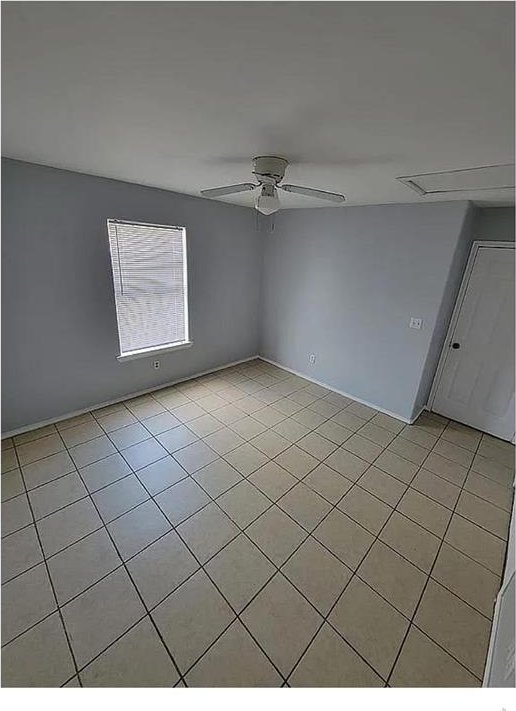 empty room featuring light tile patterned floors and ceiling fan