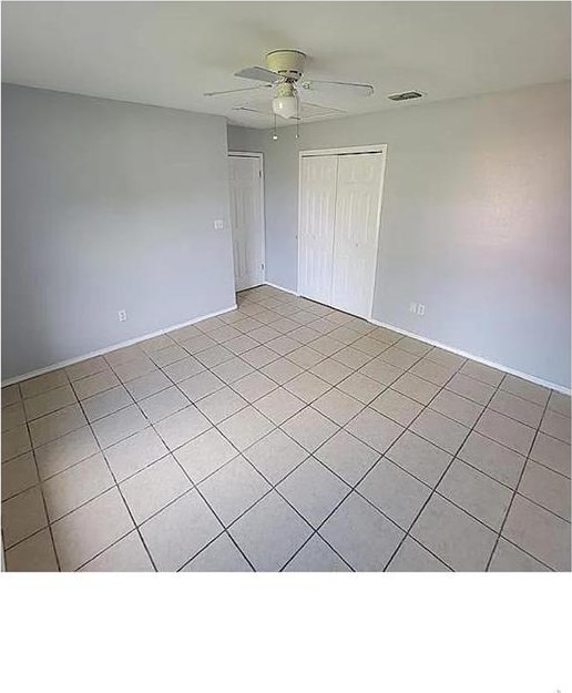 spare room with visible vents, light tile patterned floors, and a ceiling fan