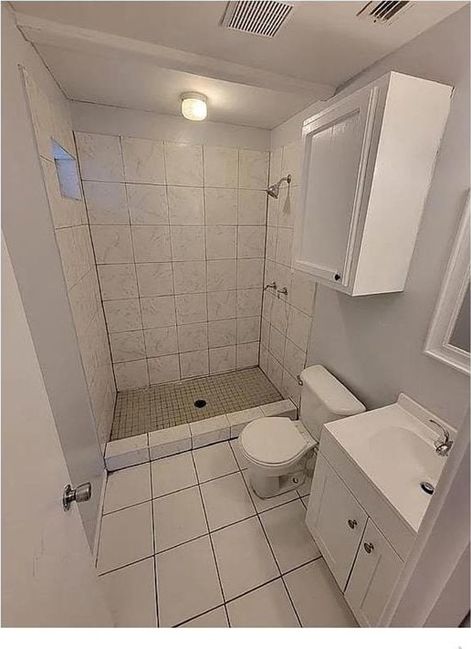 bathroom featuring toilet, a shower stall, visible vents, and vanity