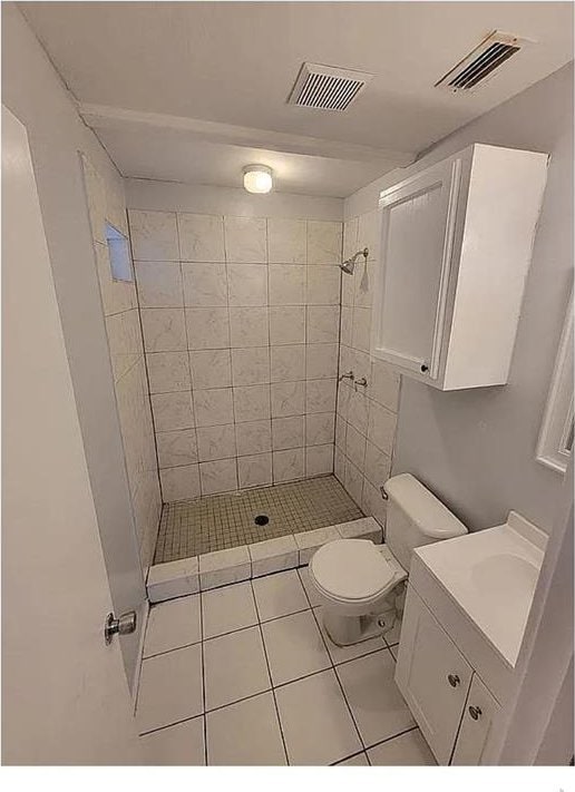 full bathroom featuring toilet, a shower stall, and visible vents